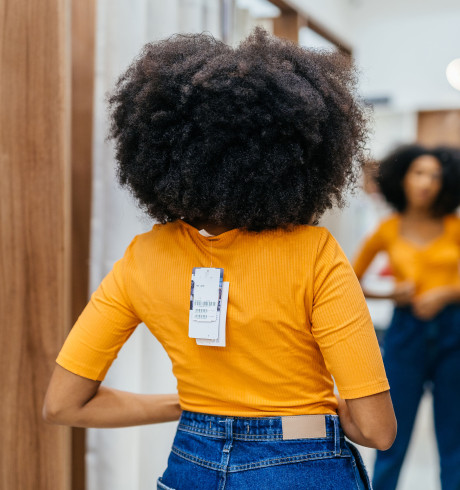 Woman trying on new clothes in front of the mirror in a fitting room