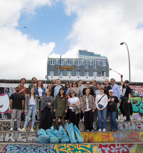 group photo of volunteers with collected garbage sacks in front of Berlin East Side Gallery