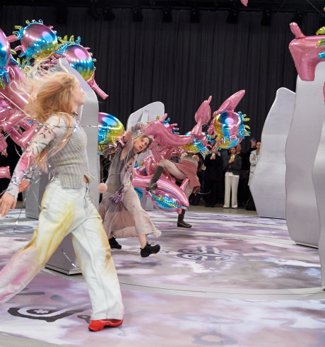 People walk the runway at Copenhagen Fashion Week with colorful balloons.