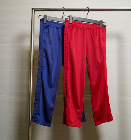 Blue and red trainer pants with buttons at the sides