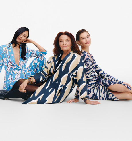Diane von Furstenberg sitting on the ground between two models