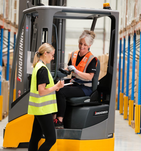 Two female logistics workers in a warehouse setting