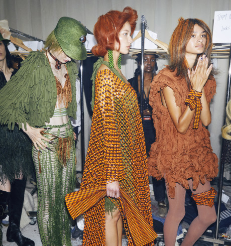 four fashion models standing in line backstage waiting their turn