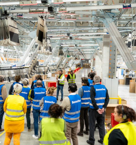 visitors gathered in a warehouse listening to the tour guide