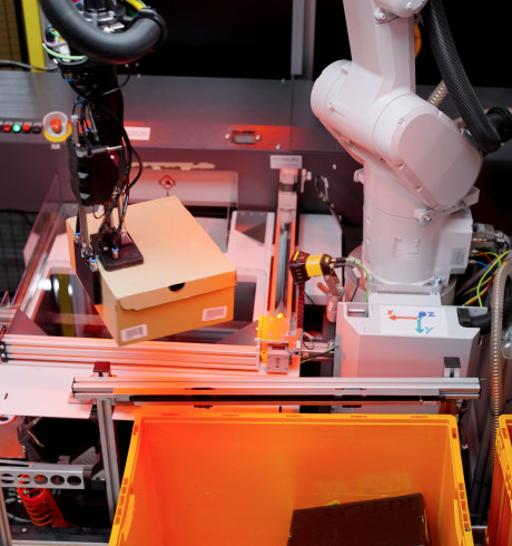 AI-driven Nomagic robot picking up a shoebox