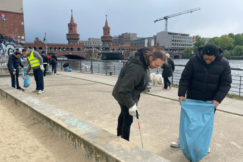 two Zalando employees collecting garbage on East Side Gallery, Berlin