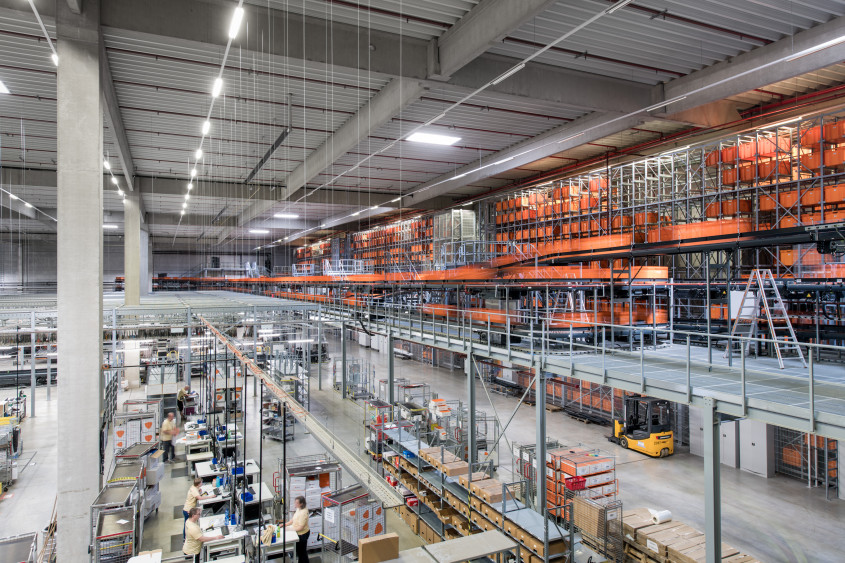 Birds-eye of fulfillment center hall with lots of orange boxes