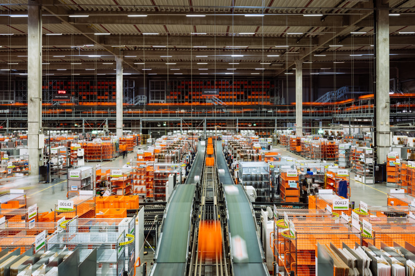 Birds-eye of fulfillment center hall with lots of orange boxes