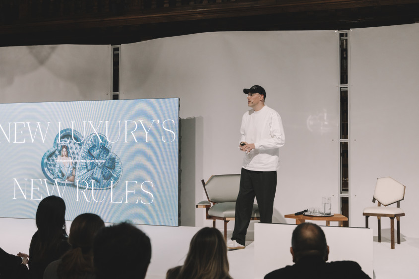 David Fischer speaking on stage; the screens behind him read: New Luxury s new rules