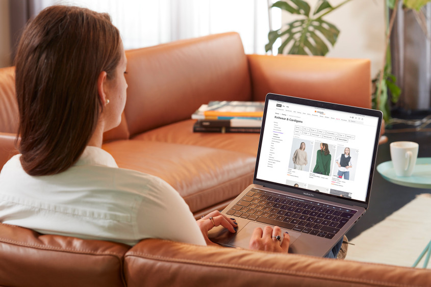 Zalando customer browsing the webshop from her sofa on a laptop computer