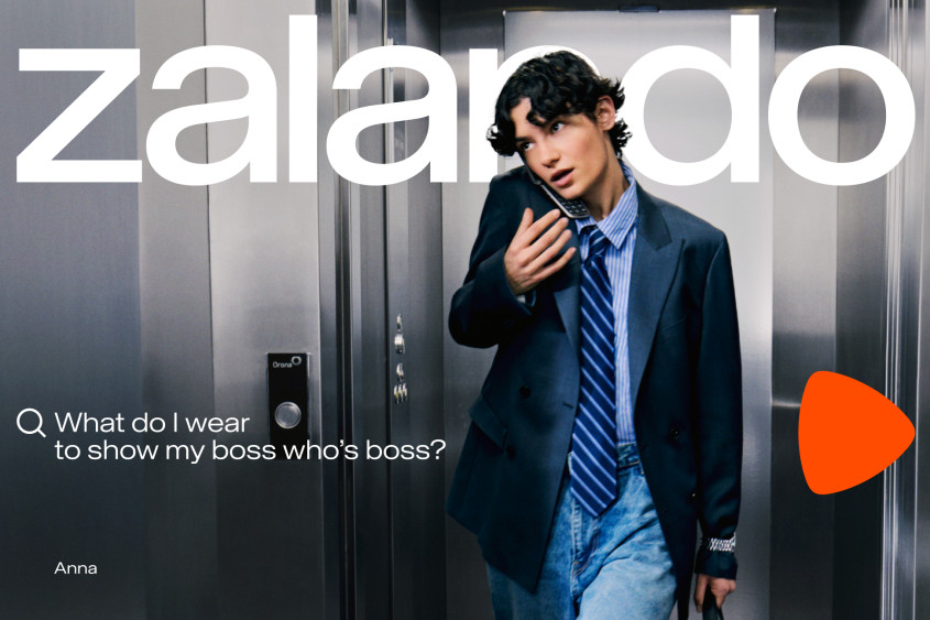 A young person wearing slightly oversized tie and jacket getting out of an elevator while on the phone; big Zalando wordmark; the copy reads: What do I wear to show my boss who's boss?