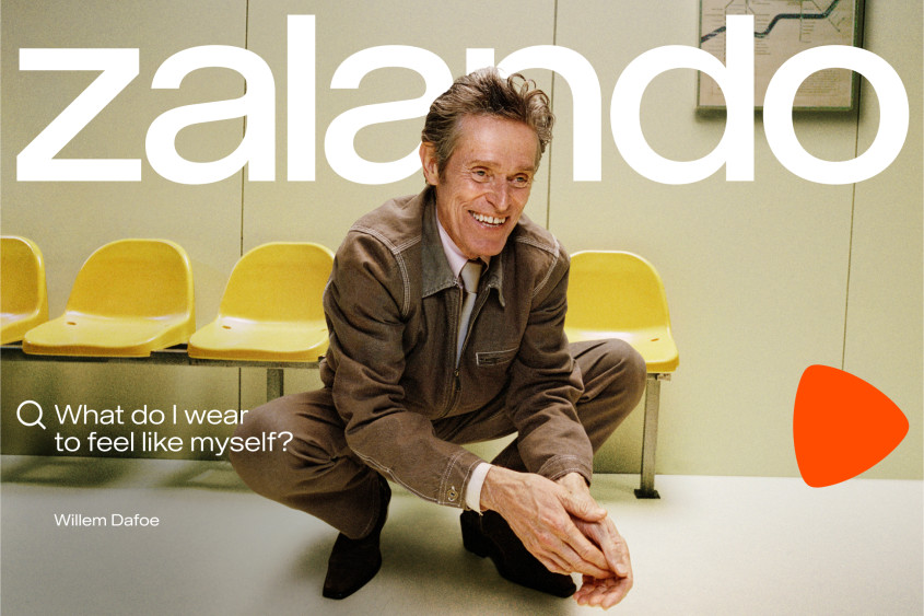 Willem Dafoe dressed in a brown suit crouching in front of a row of yellow chairs; big Zalando wordmark; the copy reads: What do I wear to feel like myself