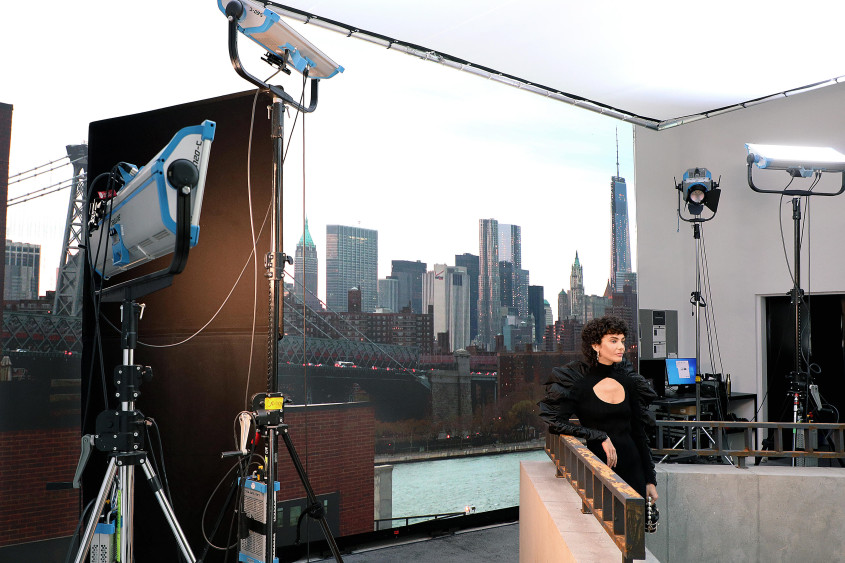 Fashion model behind the scenes in front of an impressive skyline backdrop