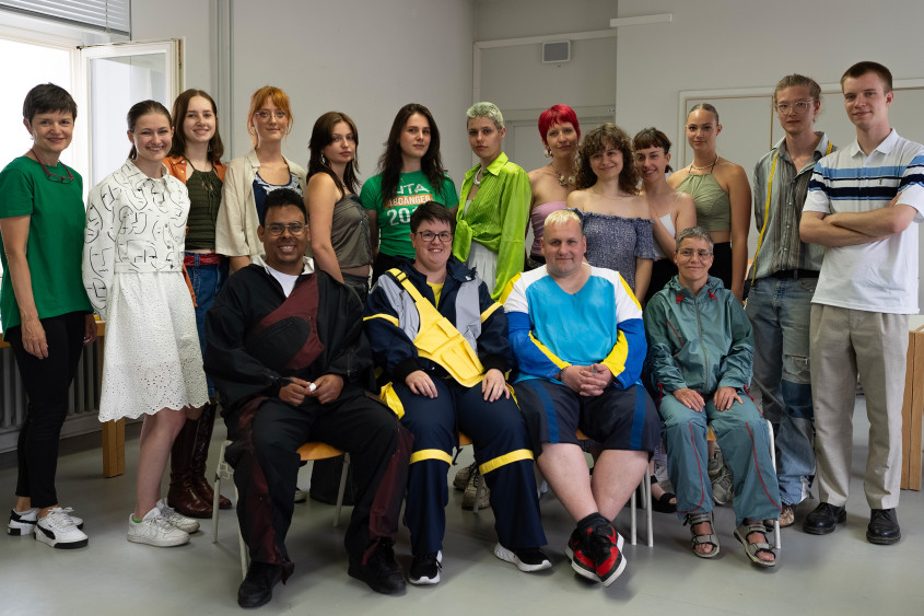 Group photo of all design students and athletes in a classroom corner