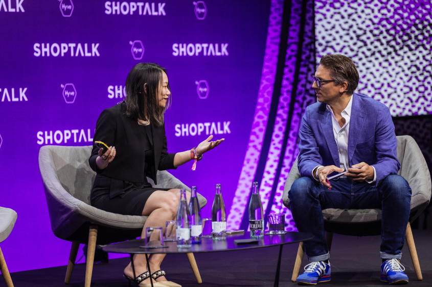 Tian Su and Dirk Cohausz talking on stage in front of a purple backdrop with the word Shoptalk