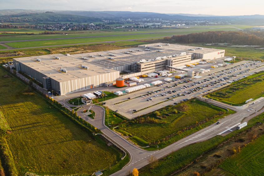 Außenansicht Logistikzentrum mit Zalando brandmark auf der Fassade und LKW davor