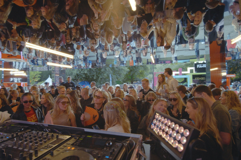 A crowd gathers in front of a DJ performing on a stage at 'The Corner' event at the Way Out West music festival in Gothenburg