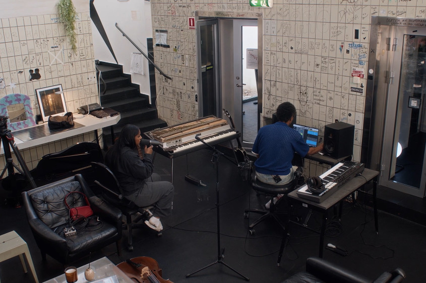 Two people are recording music in a studio at the documentary filming in Sweden
