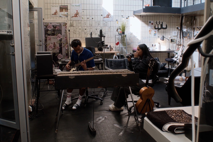Two people are recording music in a studio at the documentary filming in Sweden