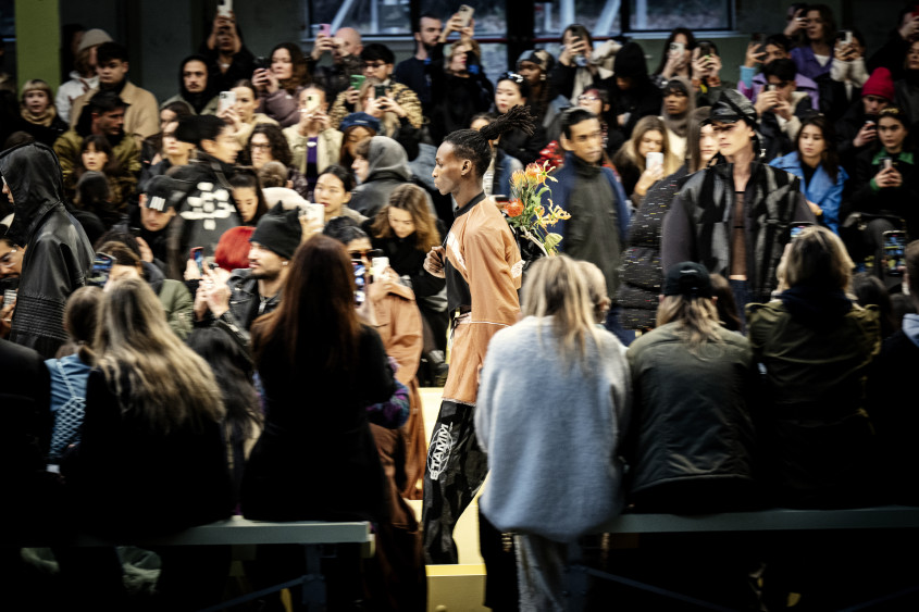 Model walking the catwalk at a busy runway show
