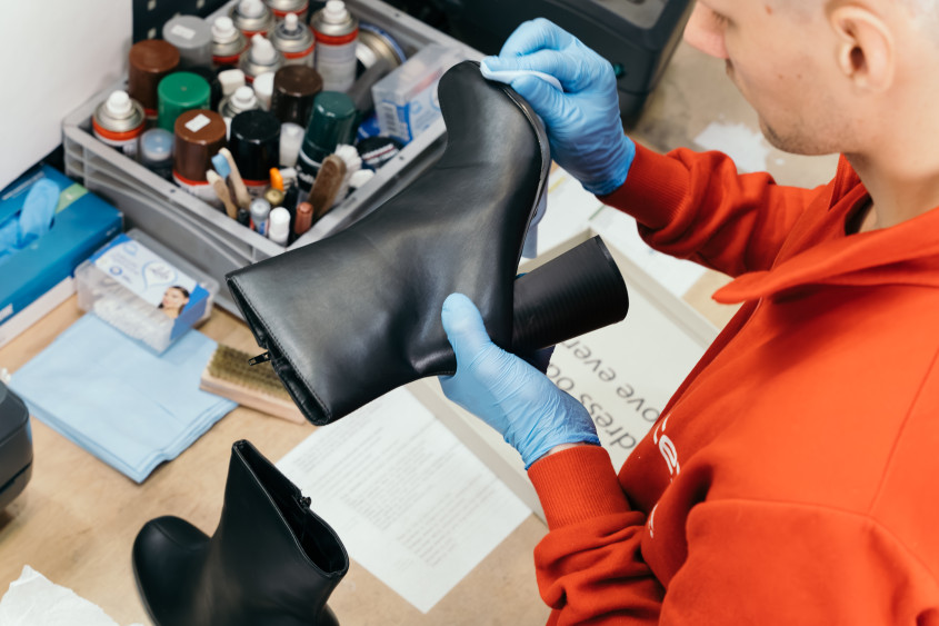 A black boot is examined for any marks or signs of wear.