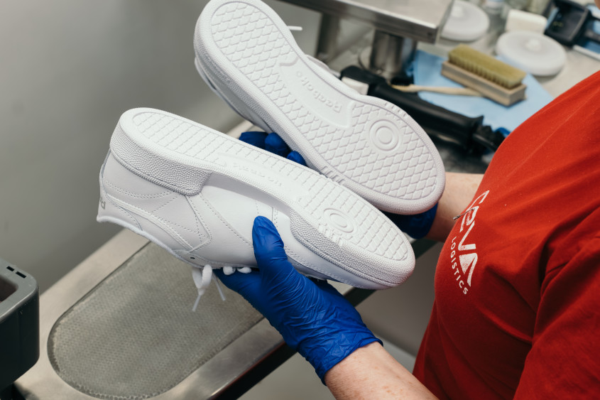 Two sneakers are being examined for any marks or signs of wear.