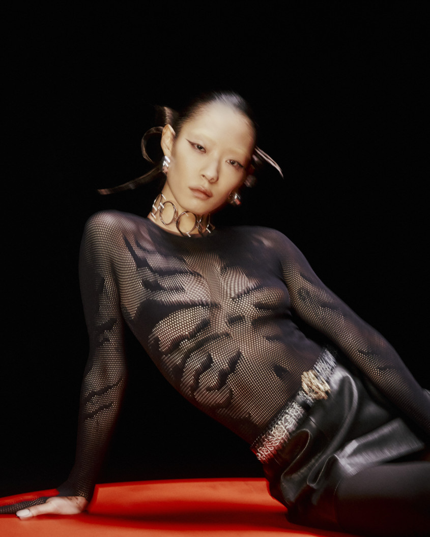 Rina Sawayama sitting in a black outfit for Zalando