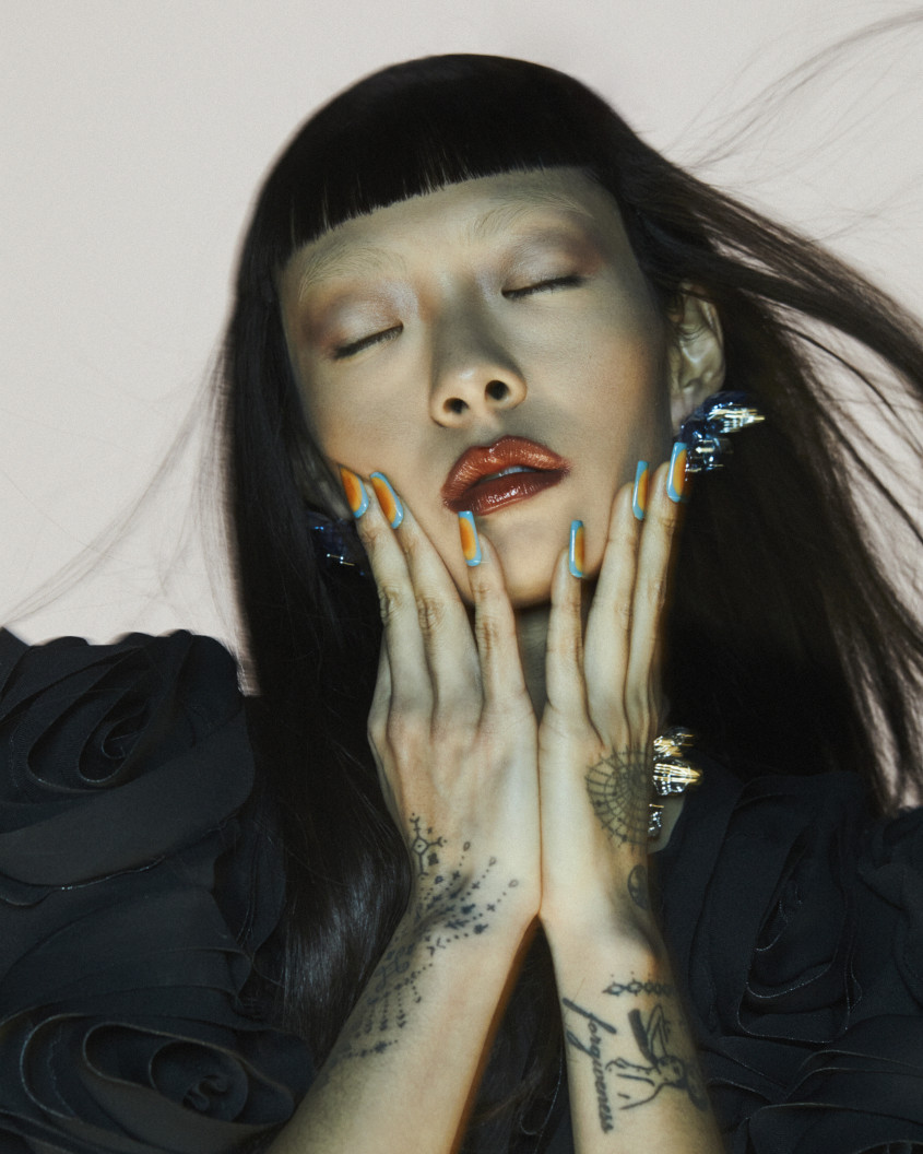 Rina Sawayama in a black outfit and very colorful fingernails for Zalando