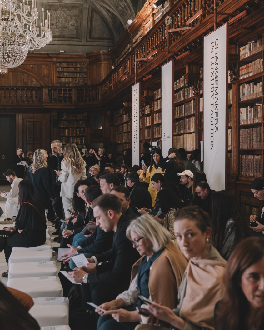 guests at the fashion event, old-fashioned bookshelves in the background
