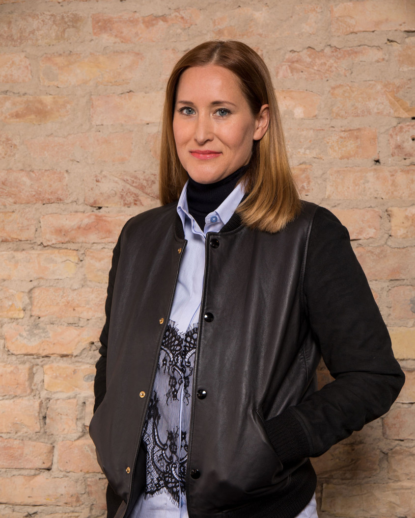 Portrait of Claudia Reth in front of a brick wall