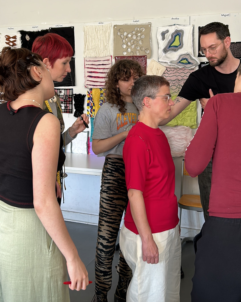 Fitting scenario; female athlete trying on clothes with designers working on her