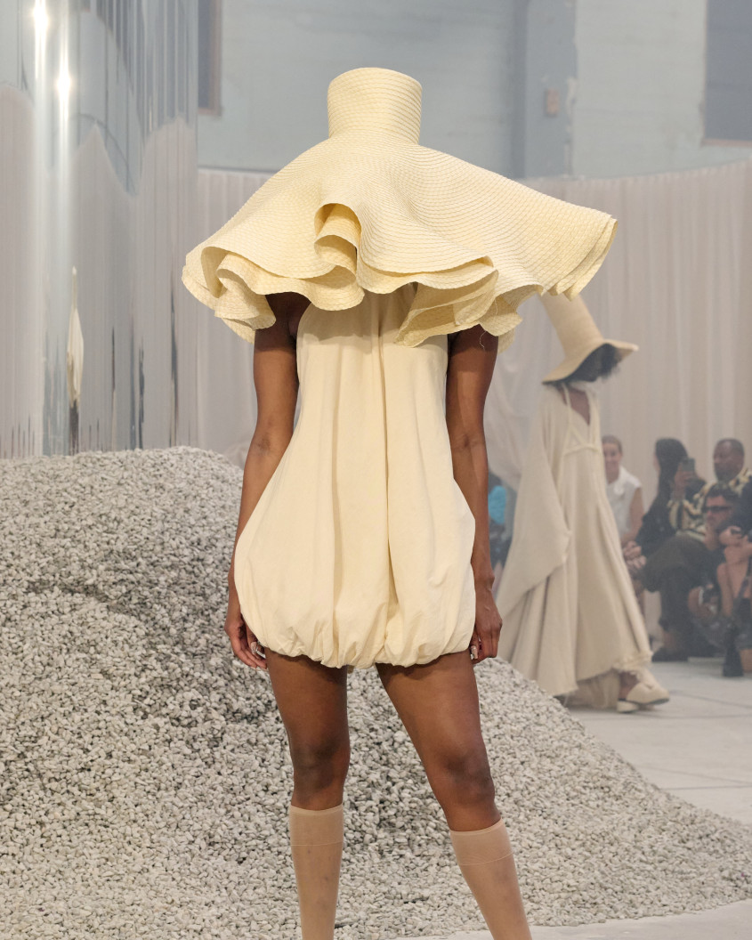 Fashion model wearing a big white floppy hat completely covering their face