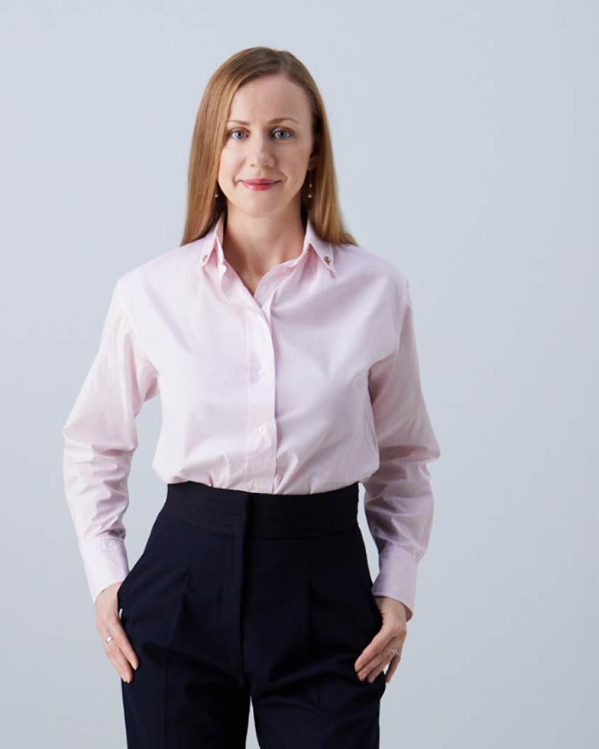 Portrait of Olga Batievskaya posing for the camera in light pink blouse and black trousers