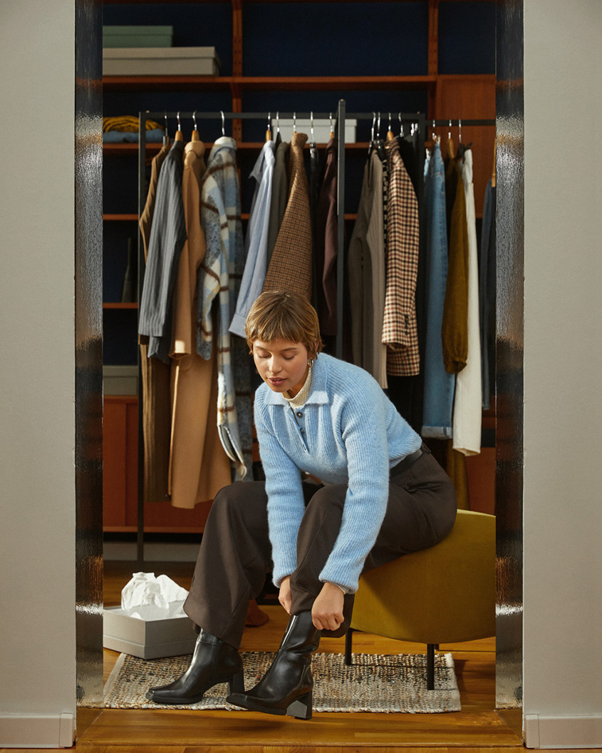 Customer in front of an open wardrobe pulling on her boots