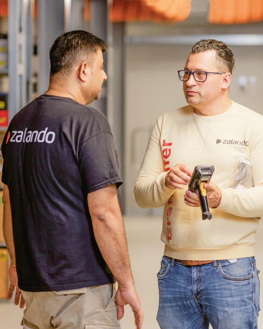 Two men in conversation in a logistics warehouse