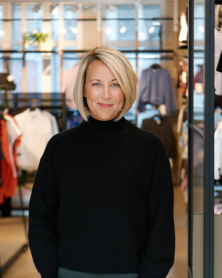 Portrait of Sarah Clark standin in the doorway of a clothes showroom