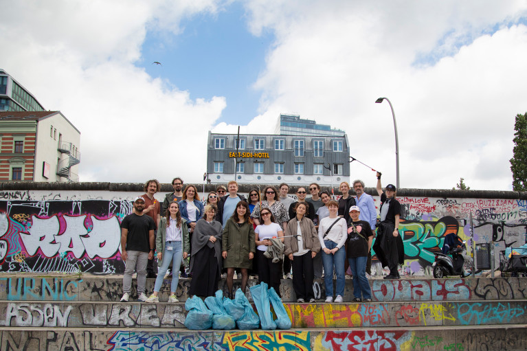 group photo of volunteers with collected garbage sacks in front of Berlin East Side Gallery