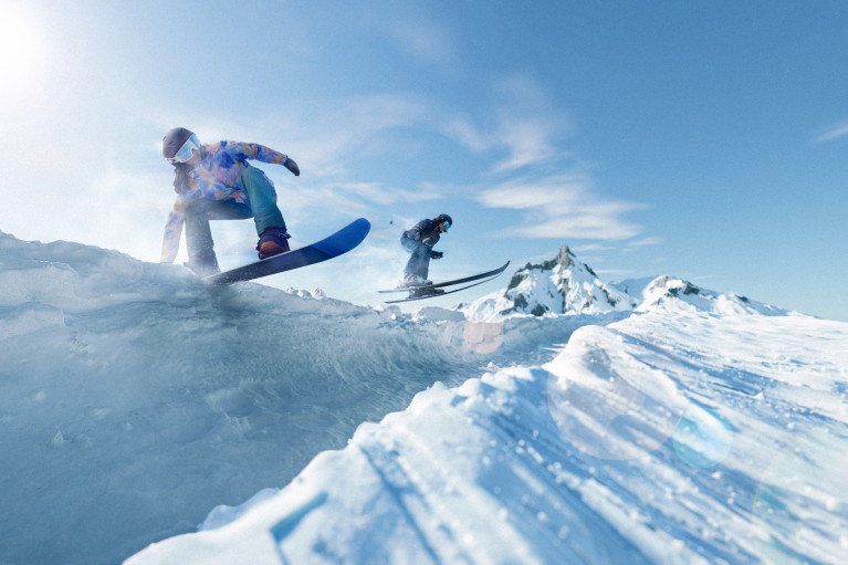 two snowboarders in action jumping over icy mountain ridges