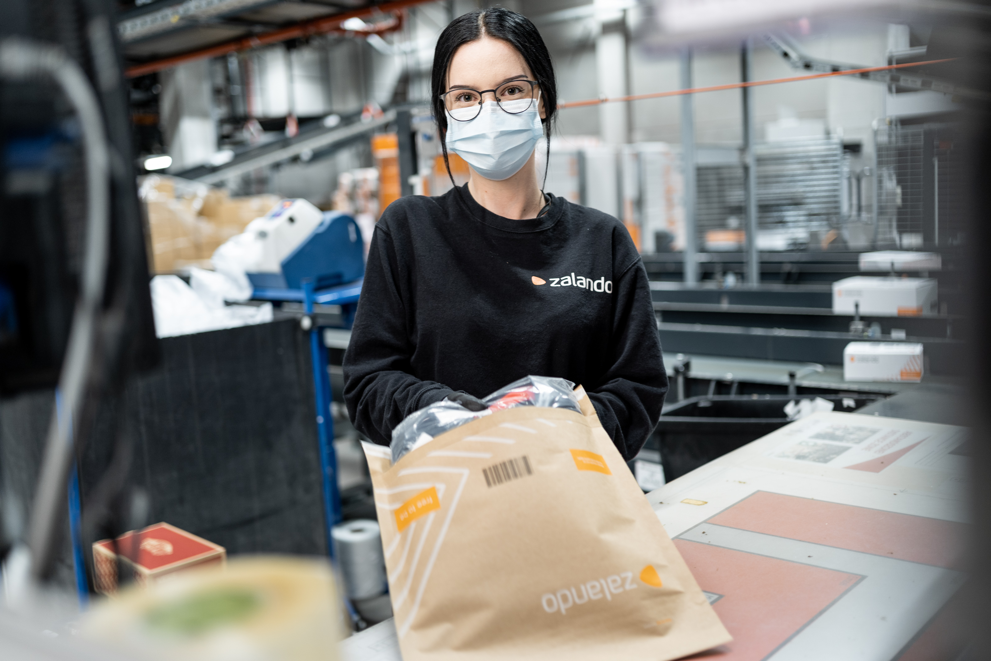 Female logistics employee wearing glasses and a medical mask