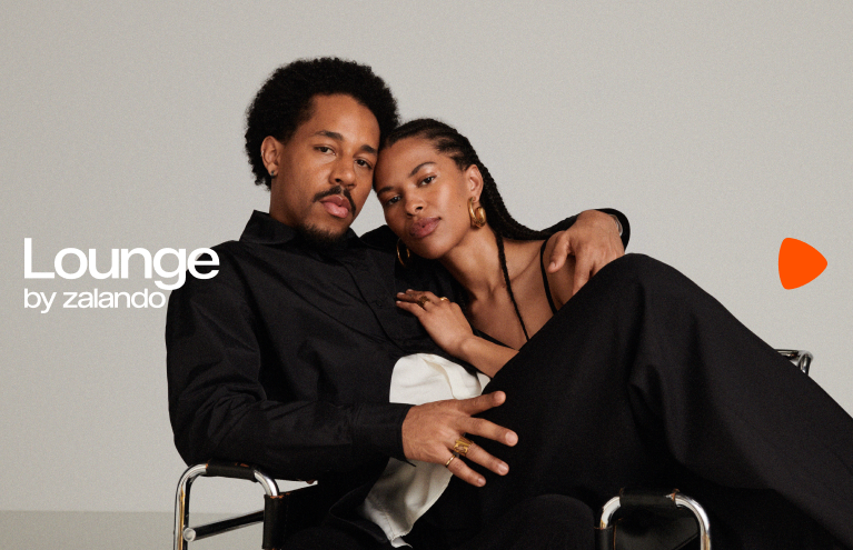 Lounge by zalando - A Black couple sitting comfortably on a chair; his arm around her, her head on his shoulder