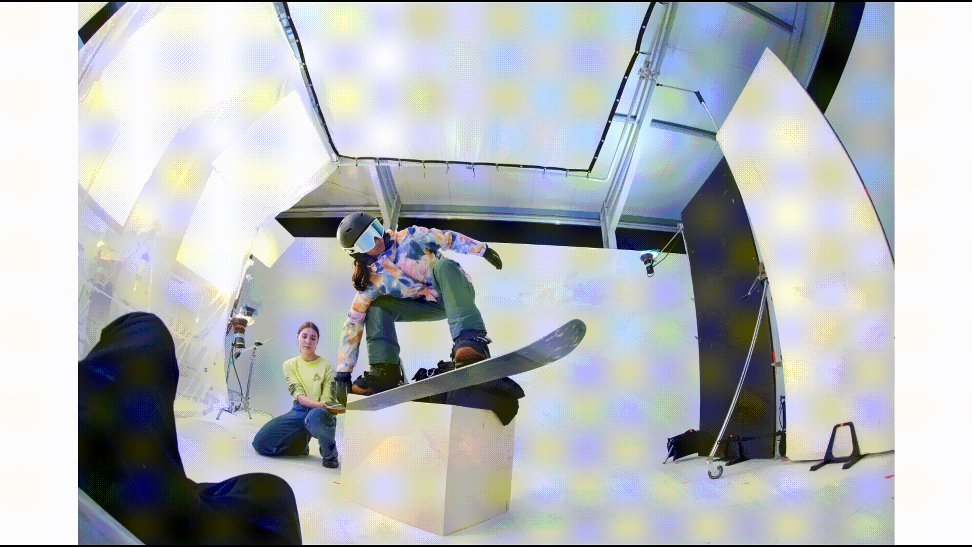 First image shows snowboarder in an indoor production space surrounded by screens; followed by a succession of graphic steps to archieve a CGI generated image of them in the mountains