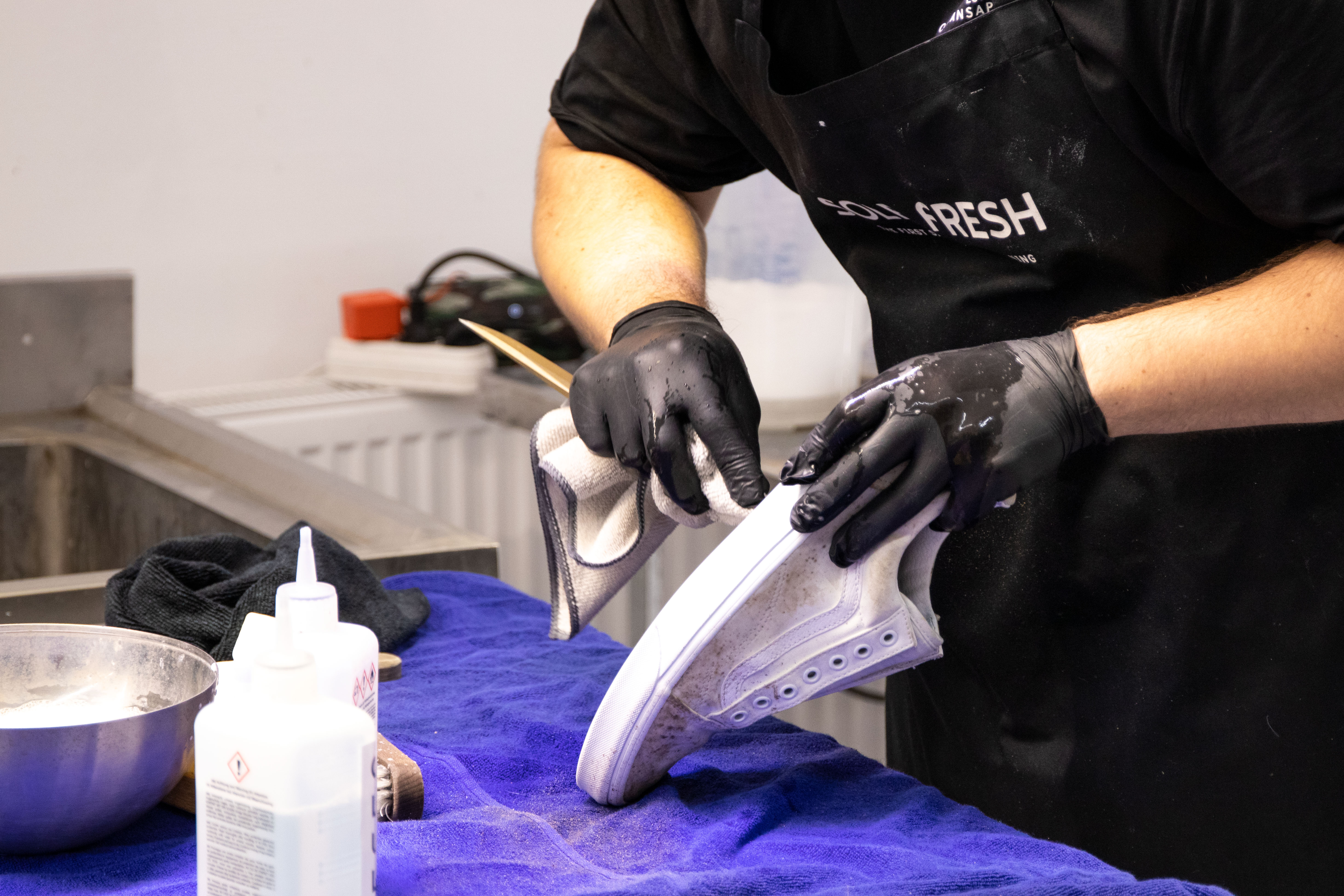 A man cleaning a used shoe