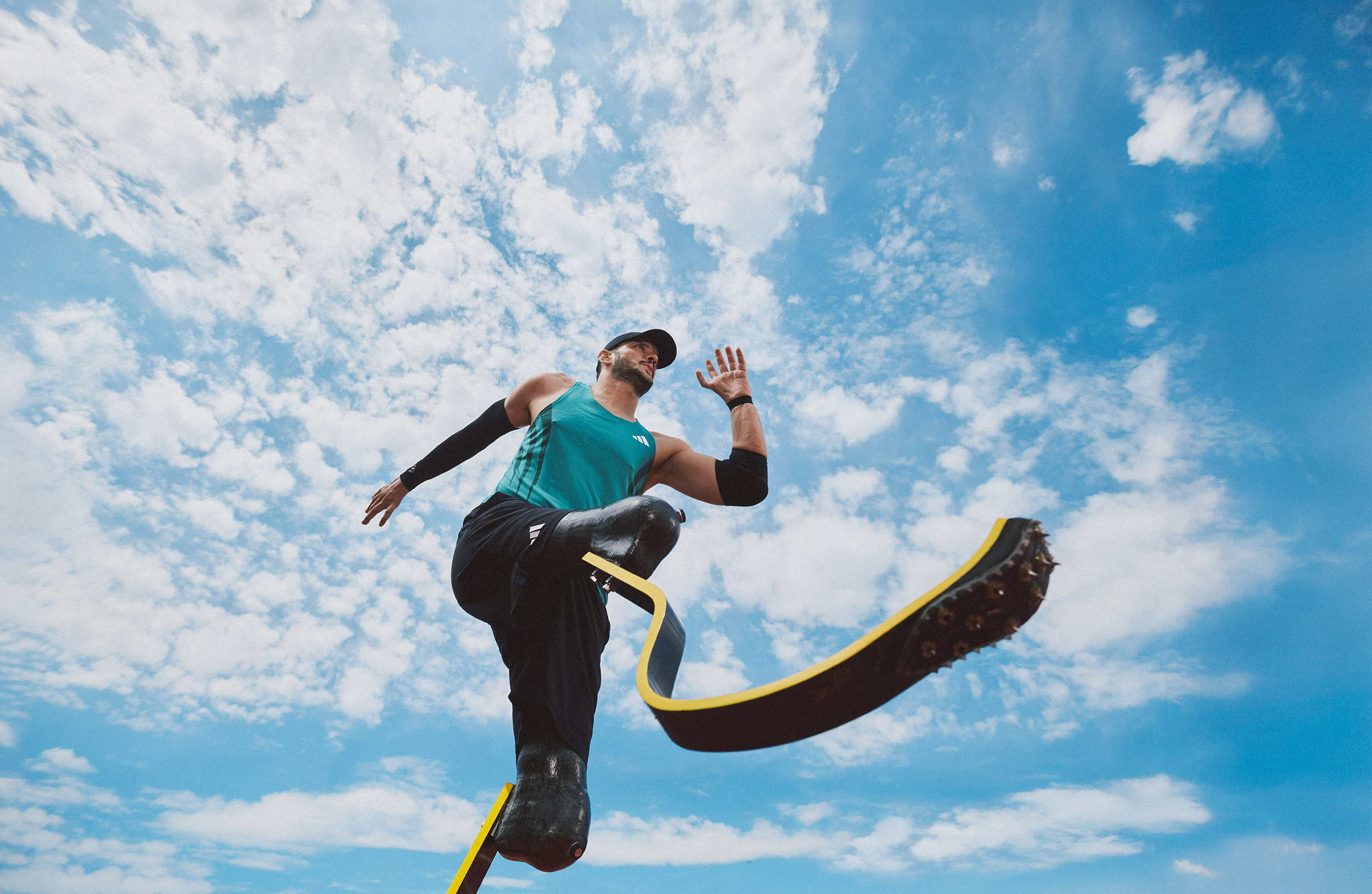 shot from below: male runner with two prosthetic legs mid-sprint