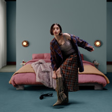 Lily Collins standing awkwardly on one leg while putting on shoes in a bedroom scenario