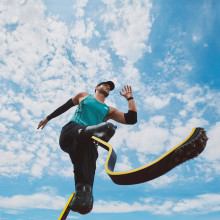 shot from below: male runner with two prosthetic legs mid-sprint