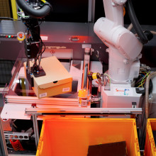 AI-driven Nomagic robot picking up a shoebox