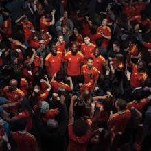 Five RBFA players standing in a celebrating crowd; only these five are looking up into the camera