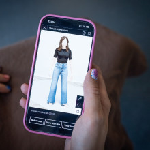 A hand with colourful nails holding a phone, showing the Zalando virtual fitting room