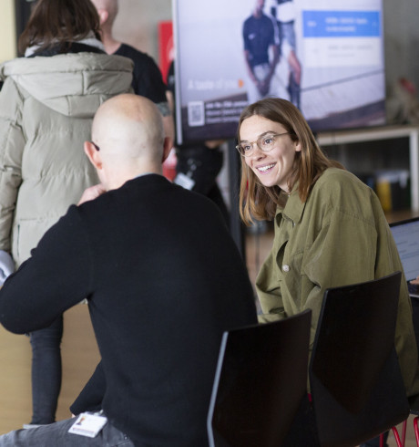 Two people, a man and a woman, are chatting in an auditorium