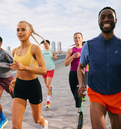 Five runners running over an urban bridge enjoying themselves